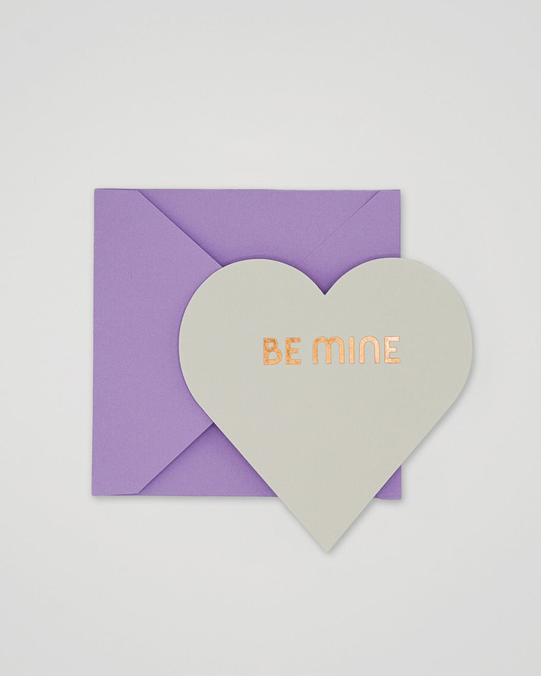 Letterpress white Valentine card in the shape of a heart with Be Mine foiled and purple envelope